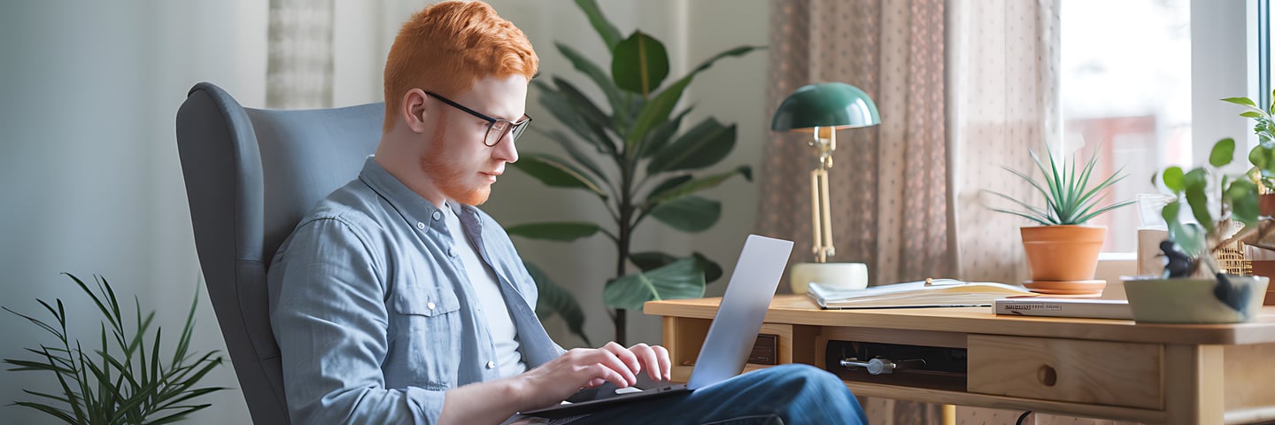 a man sitting in a chair with a laptop computer