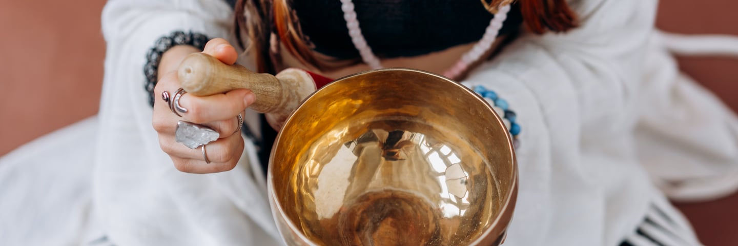A woman playing a singing bowl. It's Reiki time.