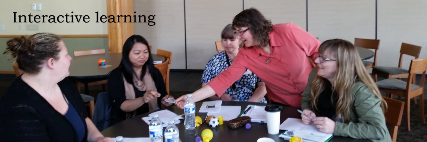 Facilitator working with adult learners at a round table.