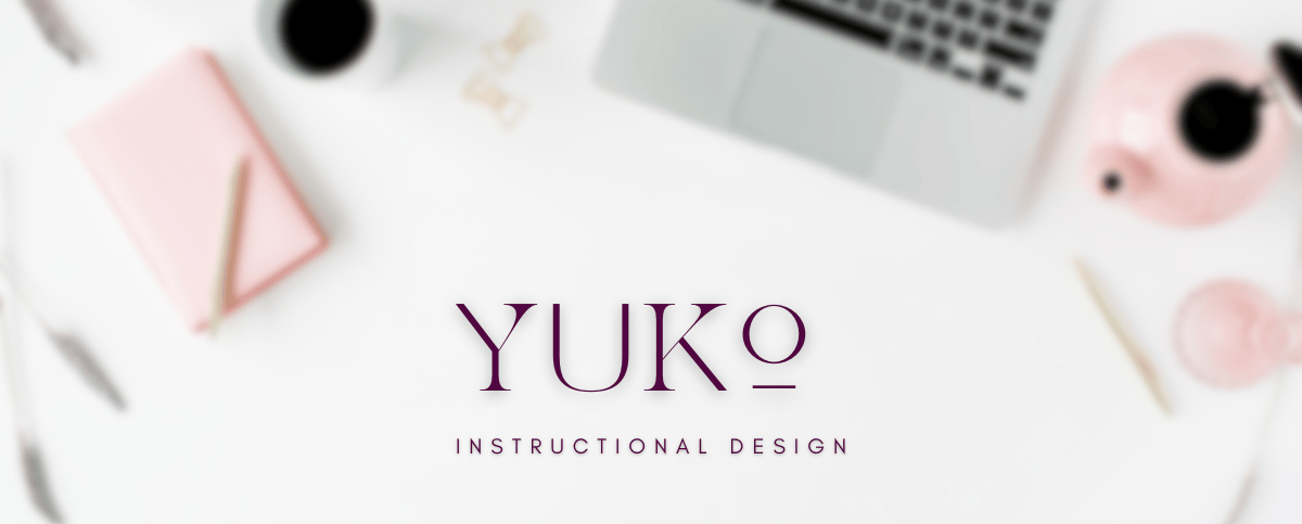 A blurry top down aesthetic desk setup with Yuko Instructional Design written.