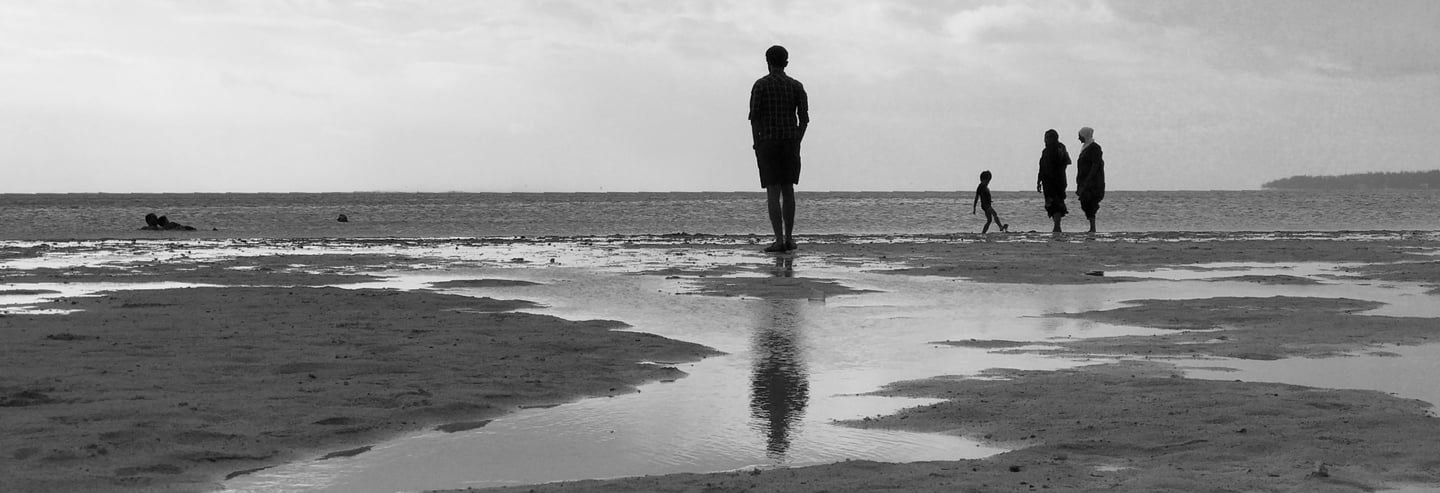 People walking along a Mauritian beach at low tide, Cape Town Photography Festival 2025.
