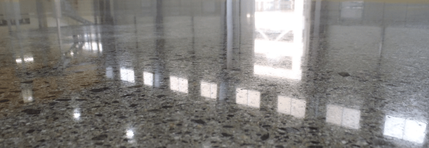 Sol en béton poli miroir, lisse et brillant, reflétant la lumière pour un effet moderne et élégant.