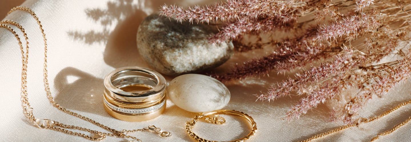 Eleganter Silberschmuck und Goldschmuck – Ringe, Kette und Armband auf Stoff mit Naturdeko – HeideSchmuck
