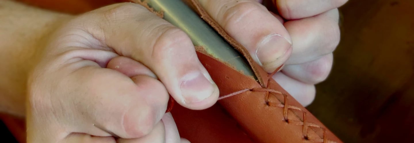 a person is holding a leather case with a leather case