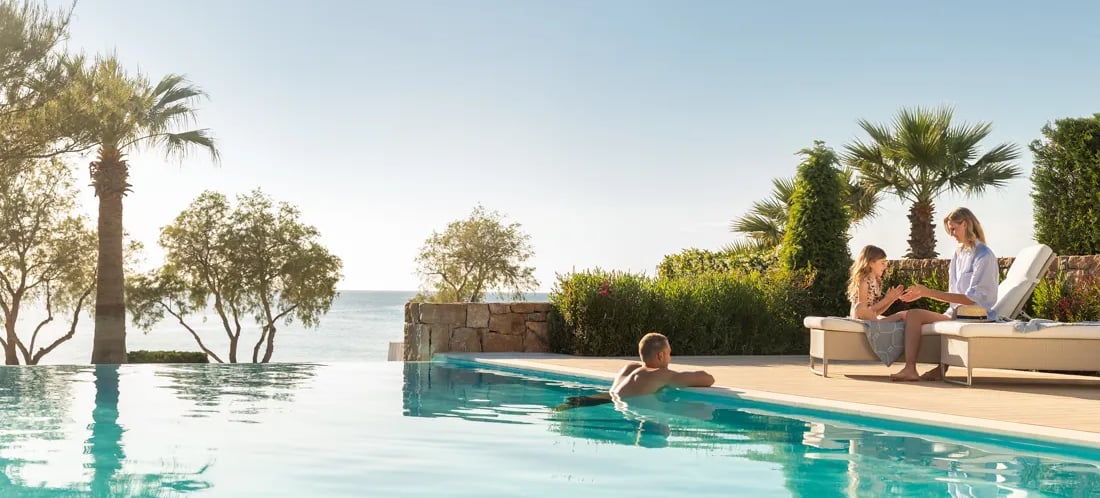 A family relaxes by a luxury infinity pool at Sani overlooking the Mediterranean 