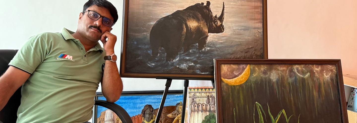 owner sitting on a chair with a paintings in background