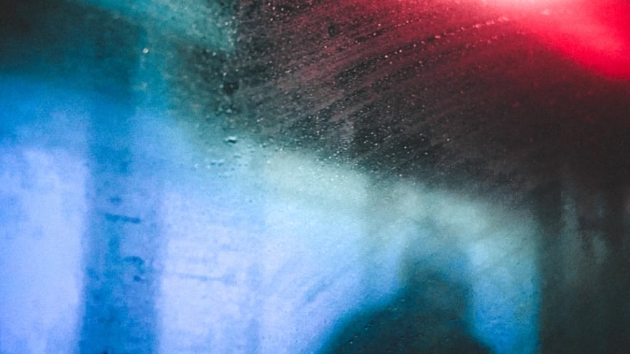 Blurred red and blue light through train window in rain