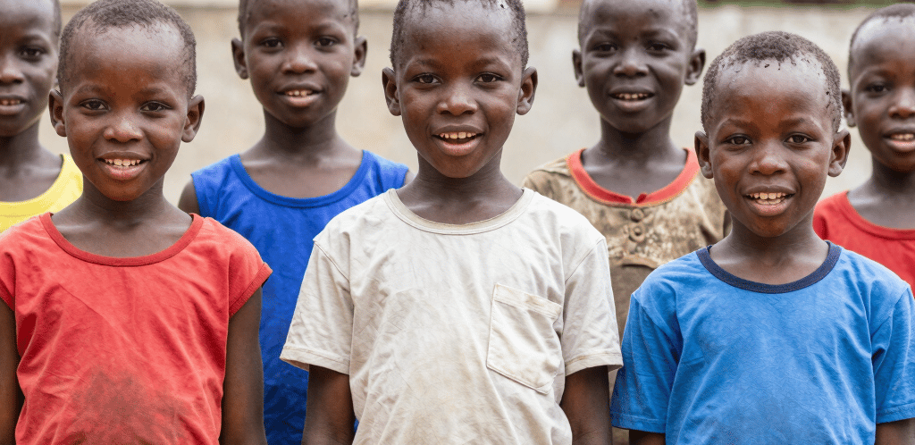 Warm, uplifting photo of African children engaged in a joyful learning activity outdoors.