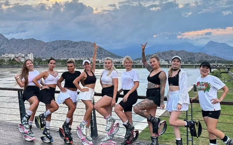 a group of women standing on a deck with kangoo jump boots