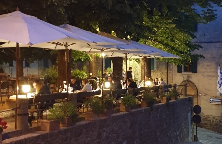 a restaurant with tables and umbrellas on a sidewalk