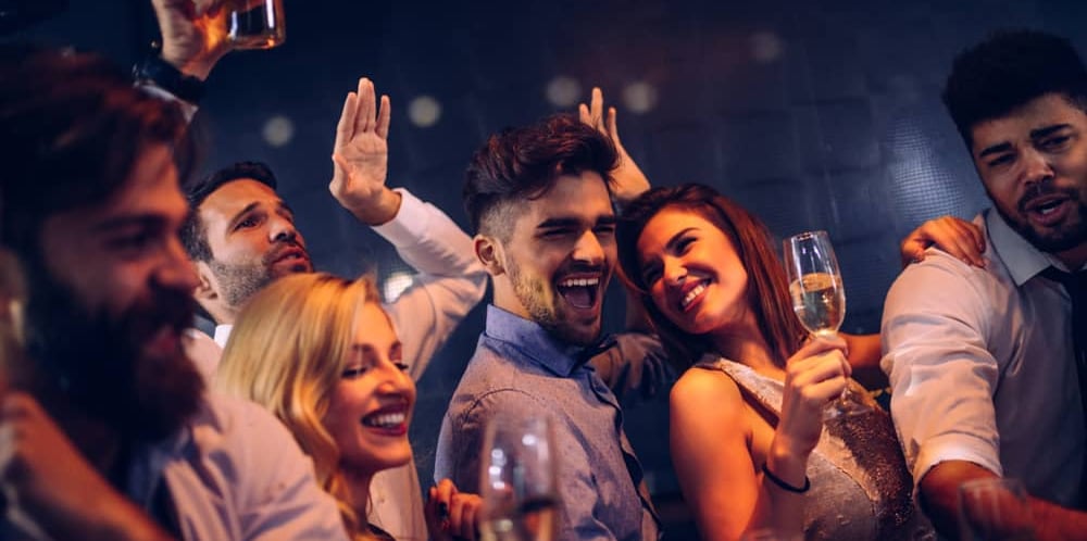 Group of friends enjoying a Las Vegas club crawl, celebrating with drinks during an exciting nightlife experience.