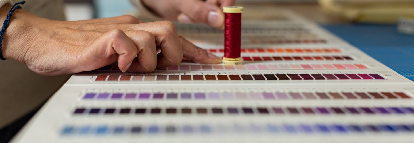 a person is holding a needle and thread thread