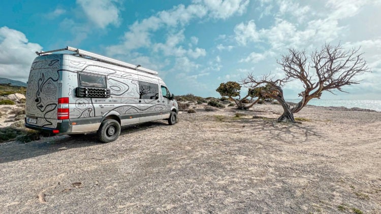 a van parked on a rocky beach