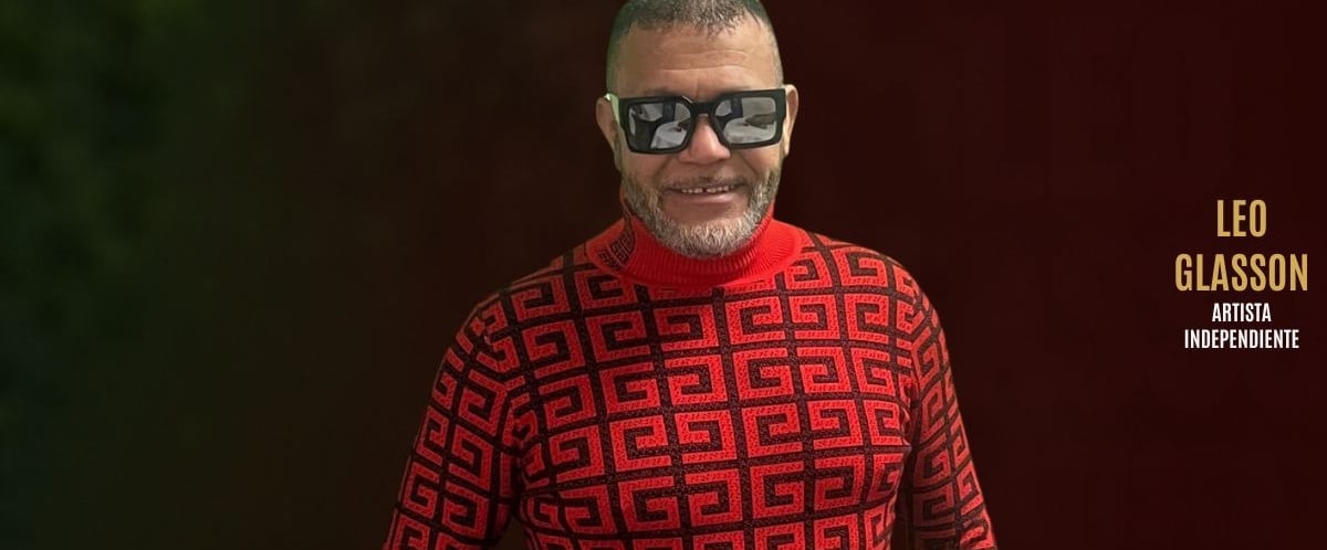 Independent artist Leo Glasson wearing sunglasses and a red patterned sweater.