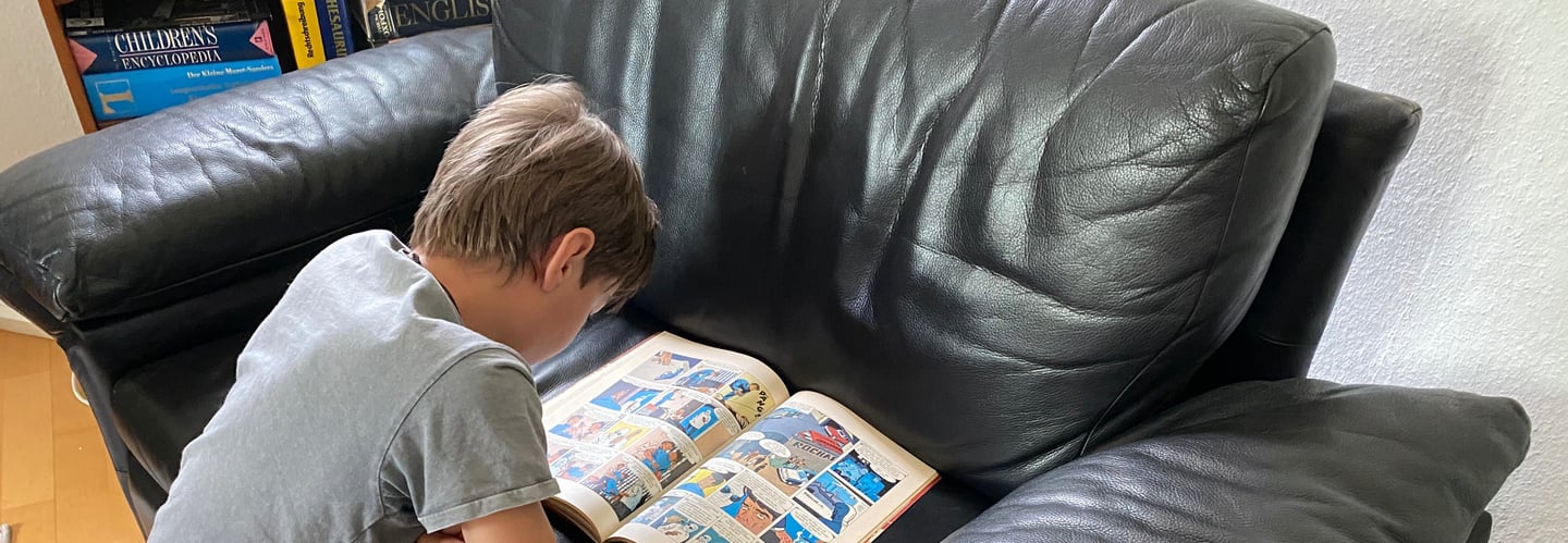 Junge liest fasziniert ein Comic-Heft