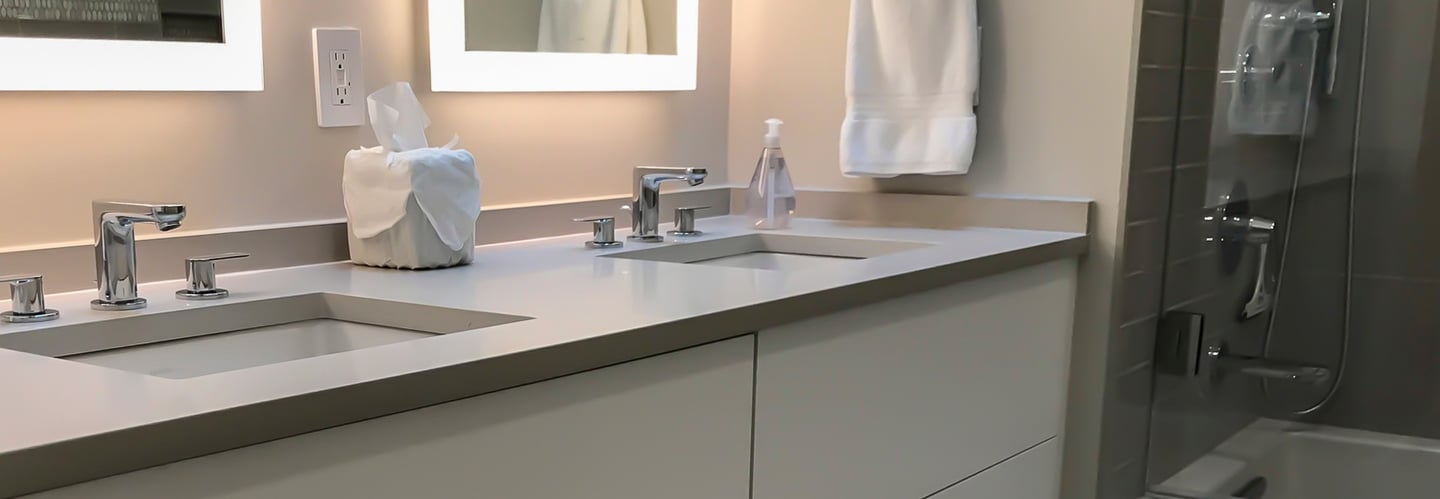 a bathroom with a large mirrors and wall hanging vanities