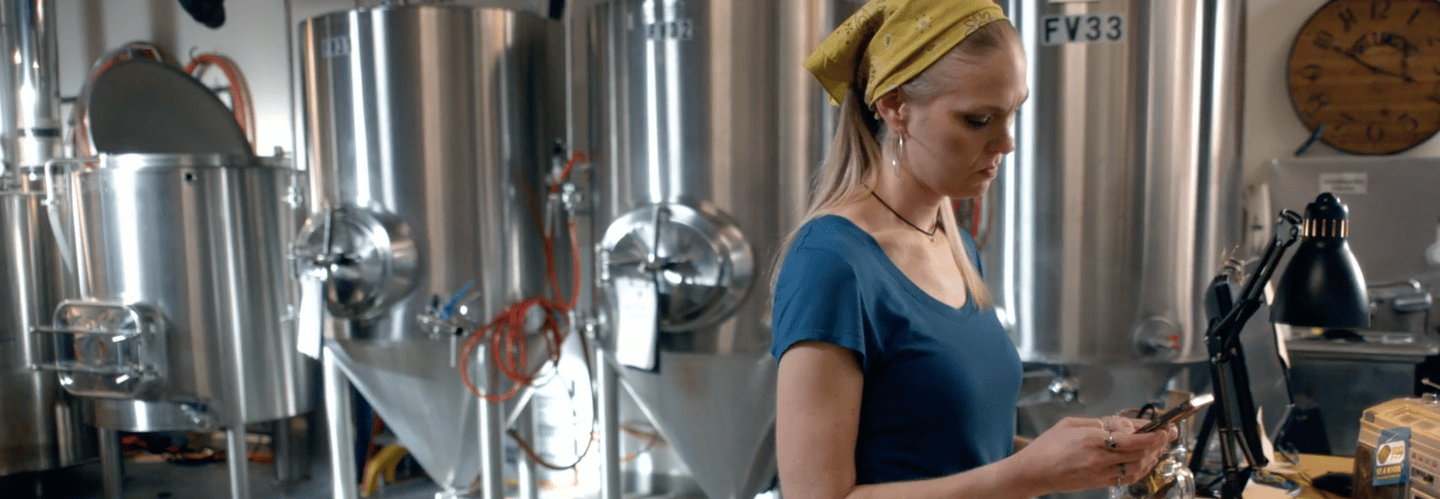 a woman in a blue shirt looking at her cell phone