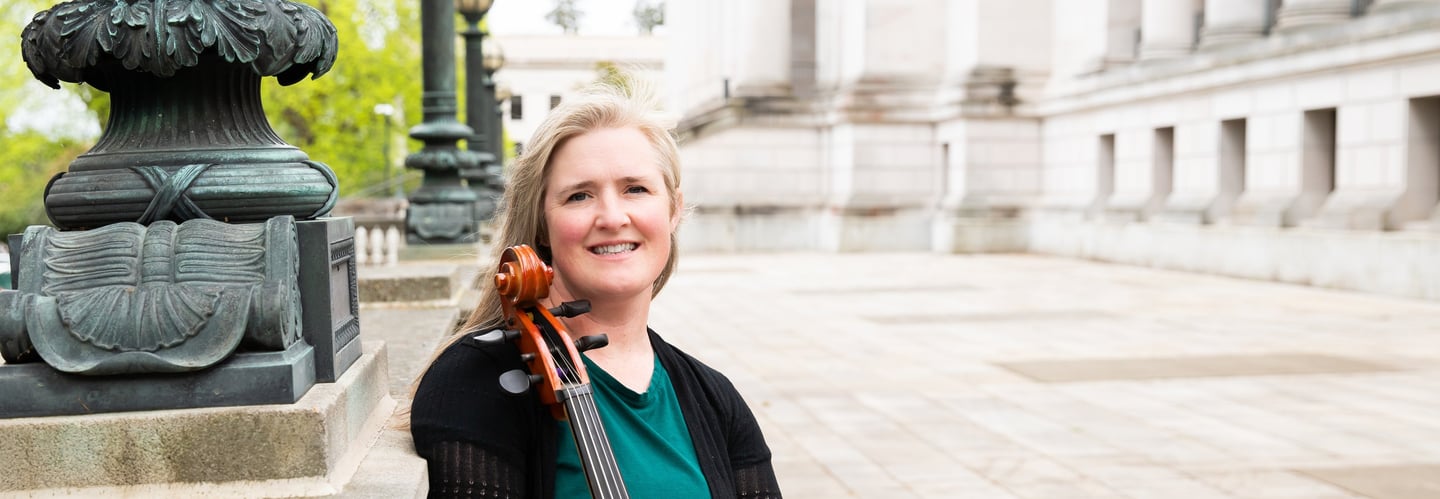 Private lesson teacher holding a cello