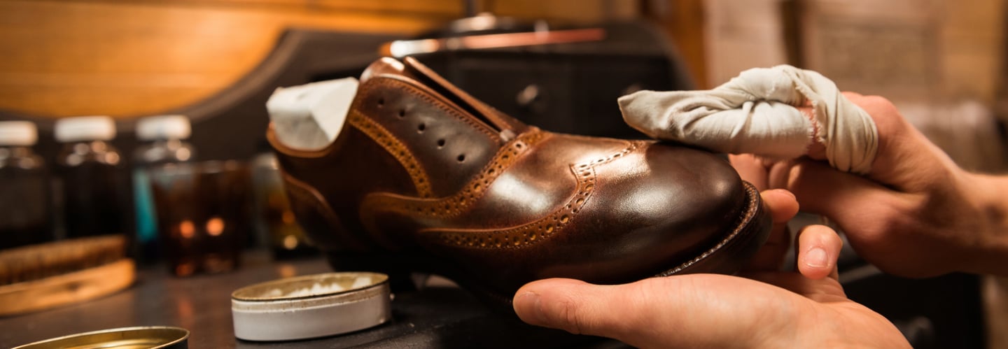 a person is cleaning a shoe with a cloth