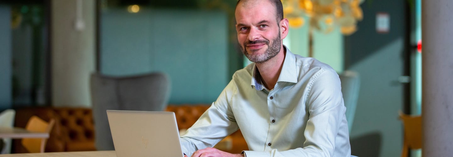 Jasper van Dieten-Blom, founder of Treeline Consulting, working on a laptop in modern office setting