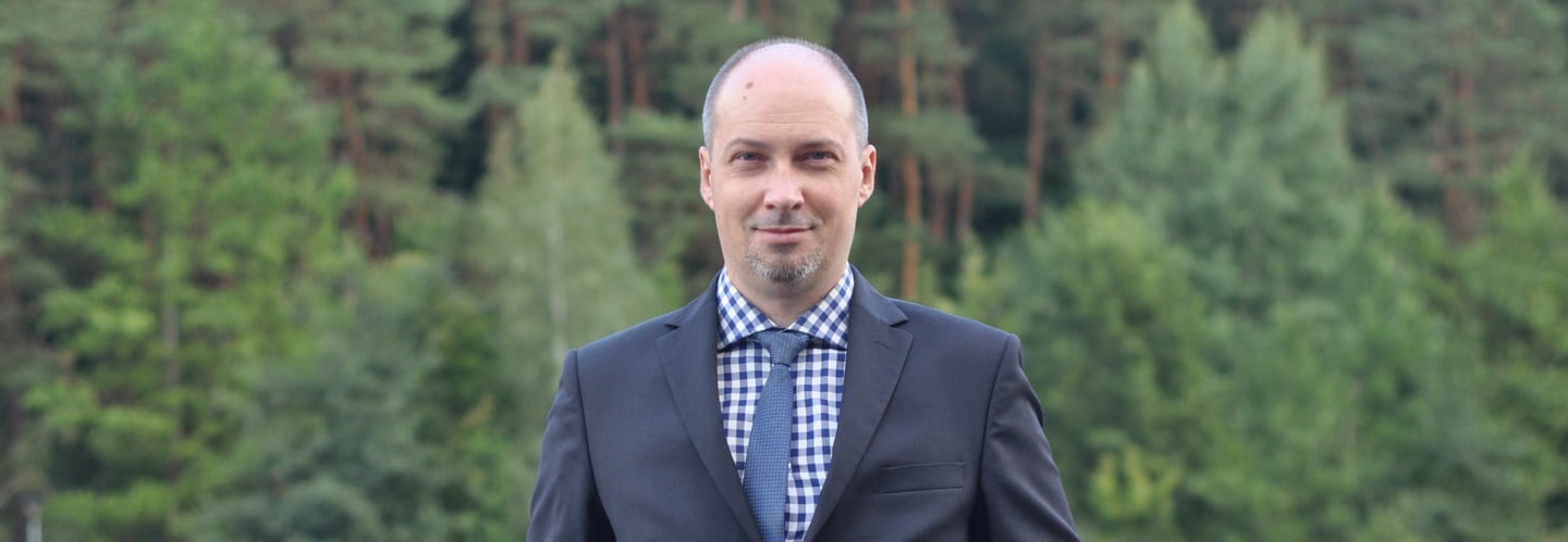 a man in a suit and tie standing on a bridge