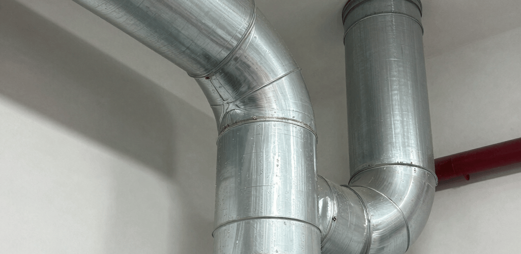 Technician carefully inspecting an air duct system with a camera in a bright, modern home.