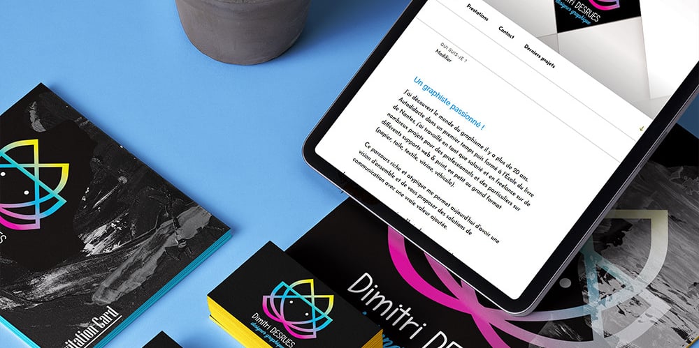 Gros plan de flyers avec logo de Dimitri Desrues designer graphique et tablette allumée