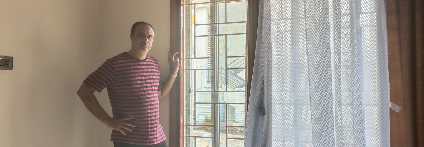 A close-up of a Velcro mosquito net neatly fitted on a wooden window frame in a Bangalore home.