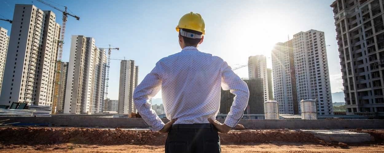 man looking at building site