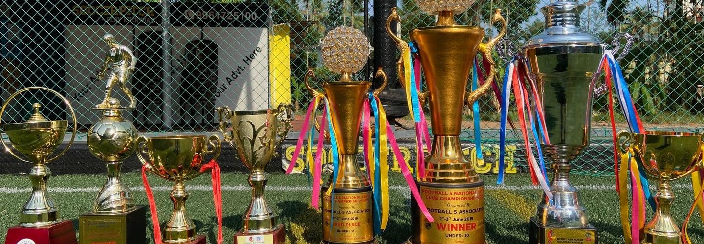 Trophies of different football tournaments in artificial football turf