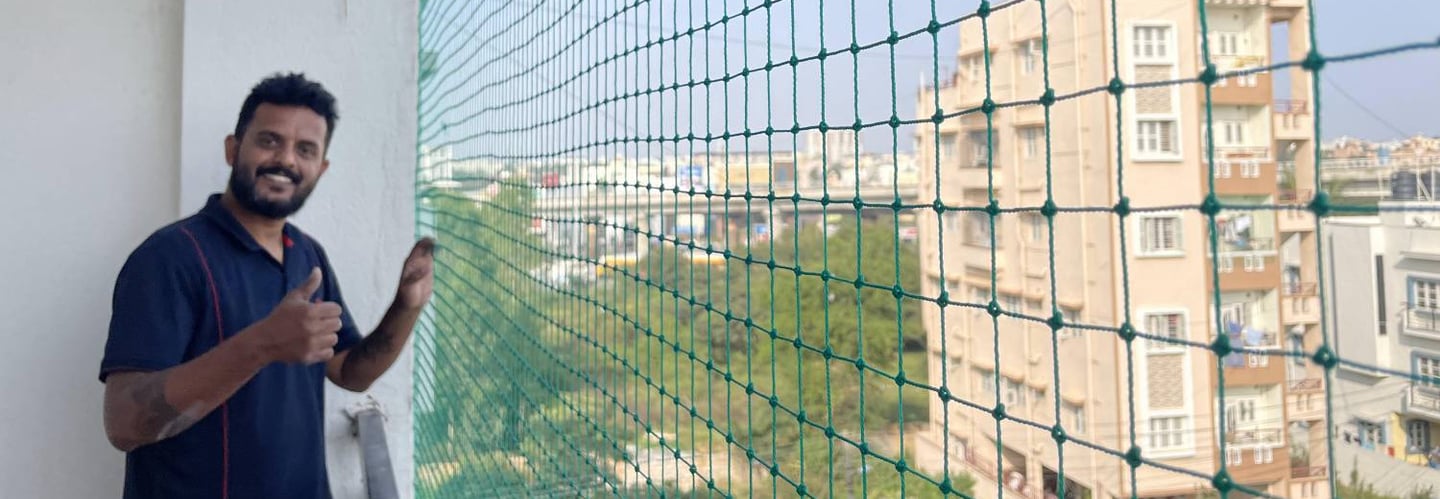 happy customer with a happy smile by the pigeon net installation in juhu mumbai