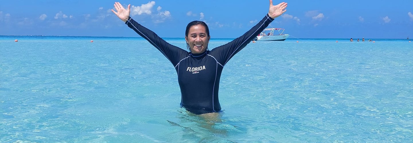 Playa azul turquesa, con un cielo azul despejado y una persona en el agua
