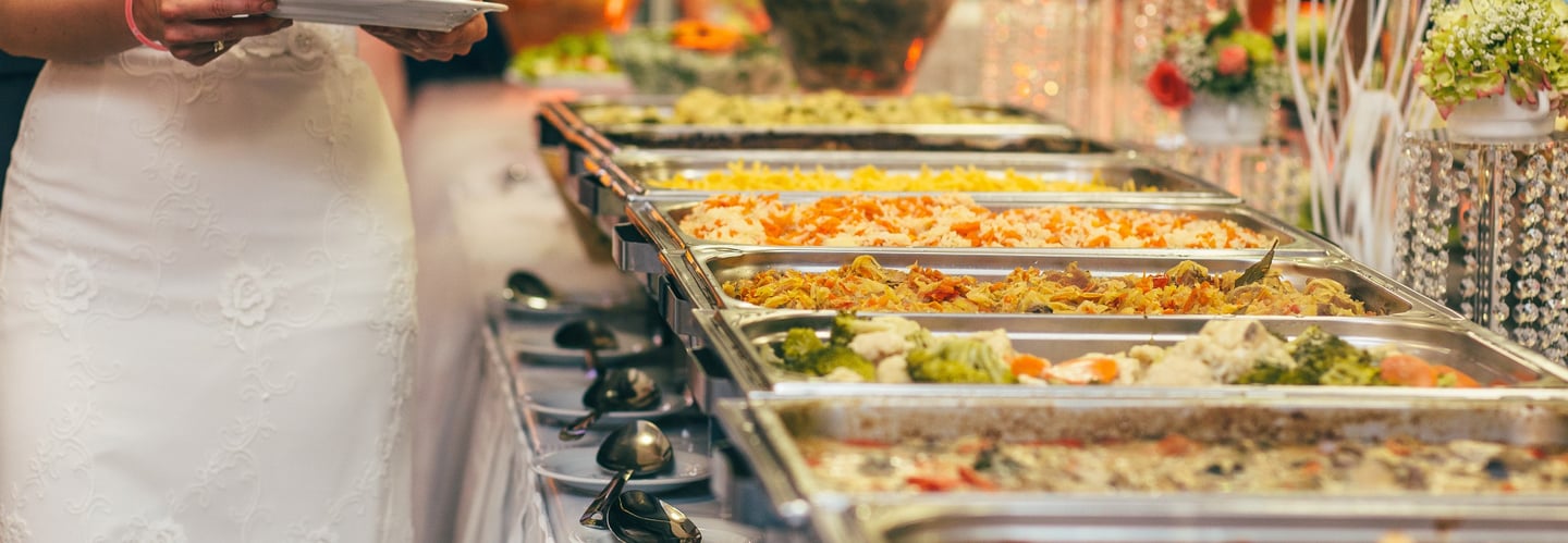 Catering a wedding reception with a woman wearing white and a line of food