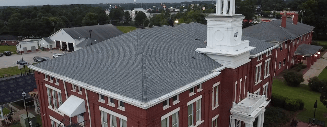 a large red brick building with a clock tower new roof