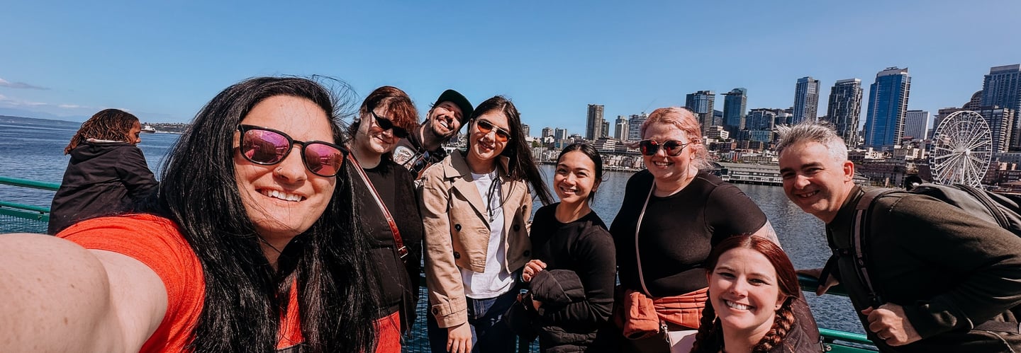 Group of coworkers enjoying the ferry ride to Bainbridge Island with views of downtown Seattle