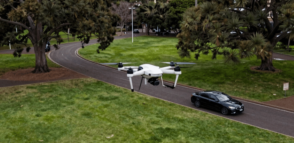 A photographer capturing a vibrant outdoor event with a cinematic drone hovering above.