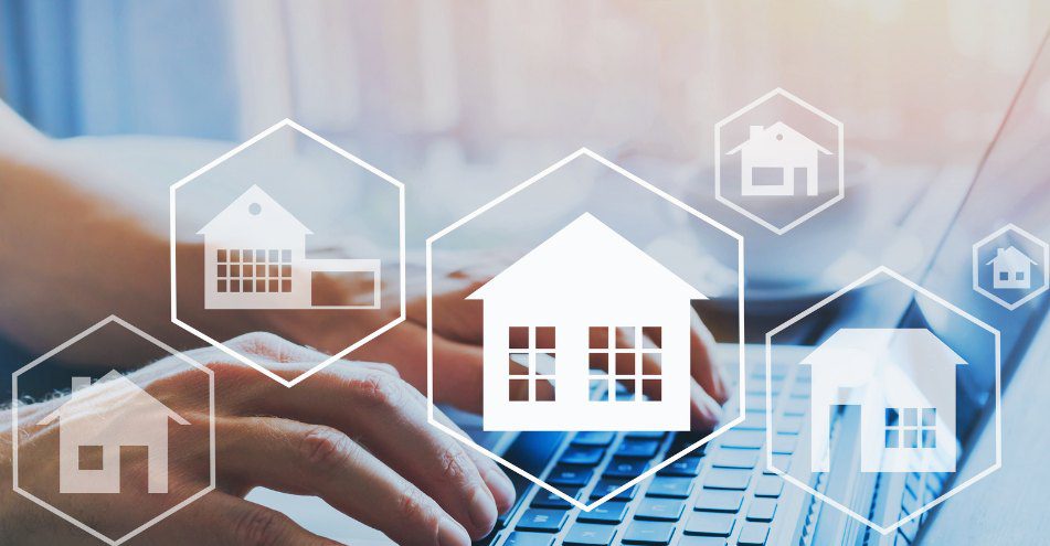 a person typing on a laptop computer with a house in the background