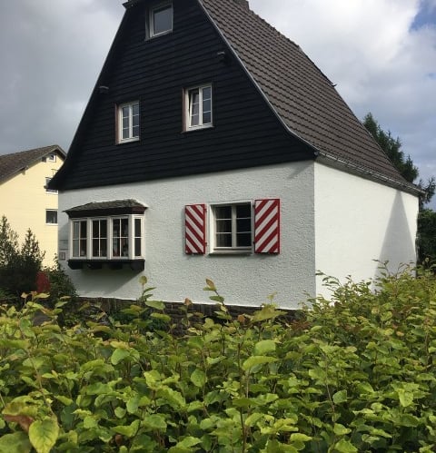 a house with a black and white house with red shutters