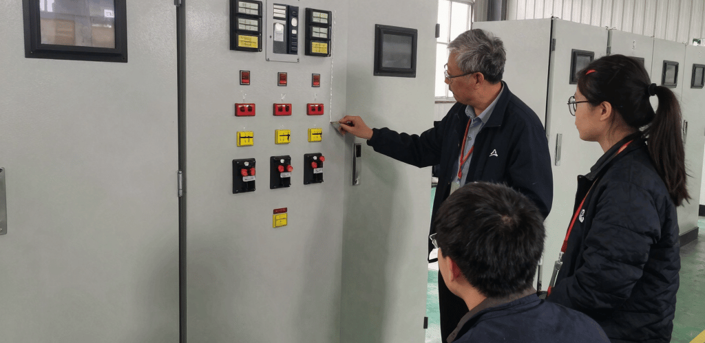 Engineers collaborating on a complex PLC panel in a modern industrial training lab.