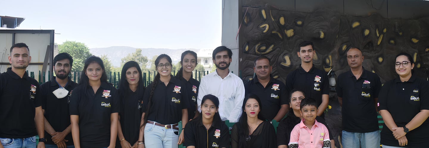 a group of people standing for click picture as a team