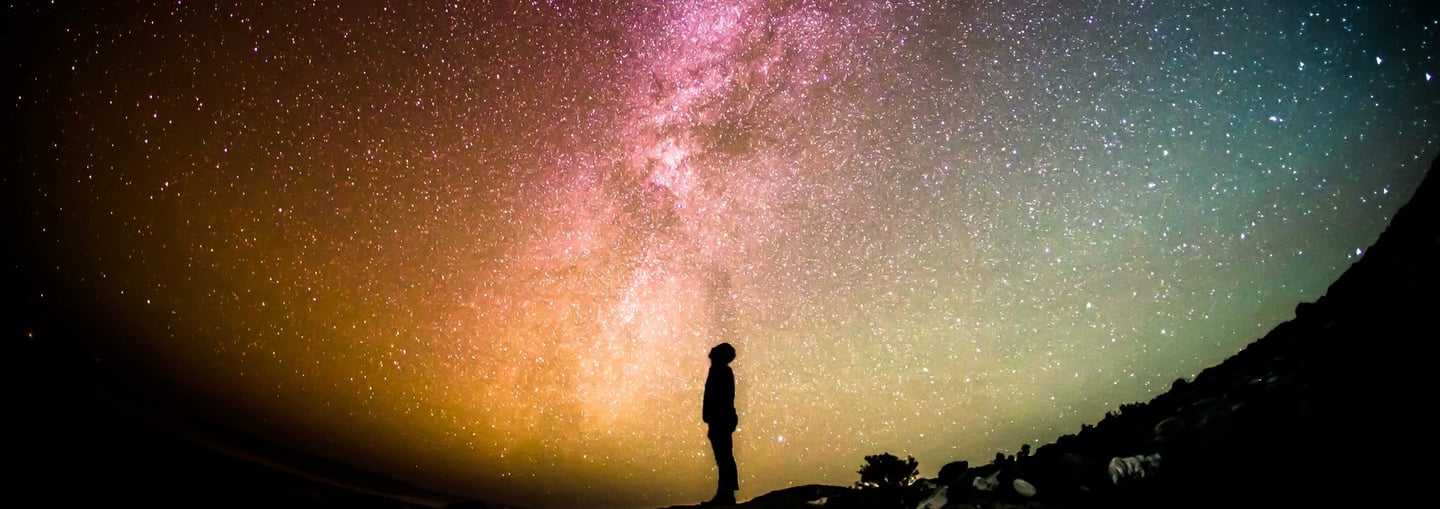 Silhouette of a man looking up to the night sky