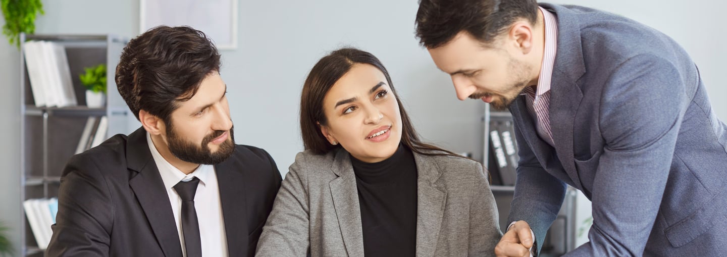 a man and woman in business attire sitting at a table