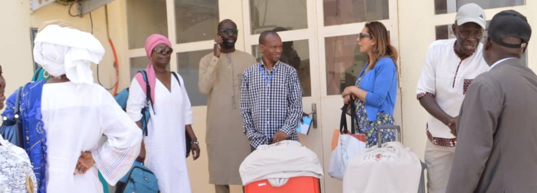 a group of people standing around a group of luggage