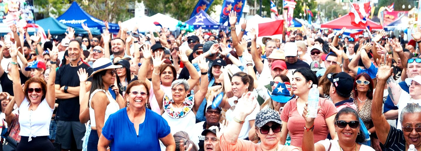 a crowd of people standing in front of a fence