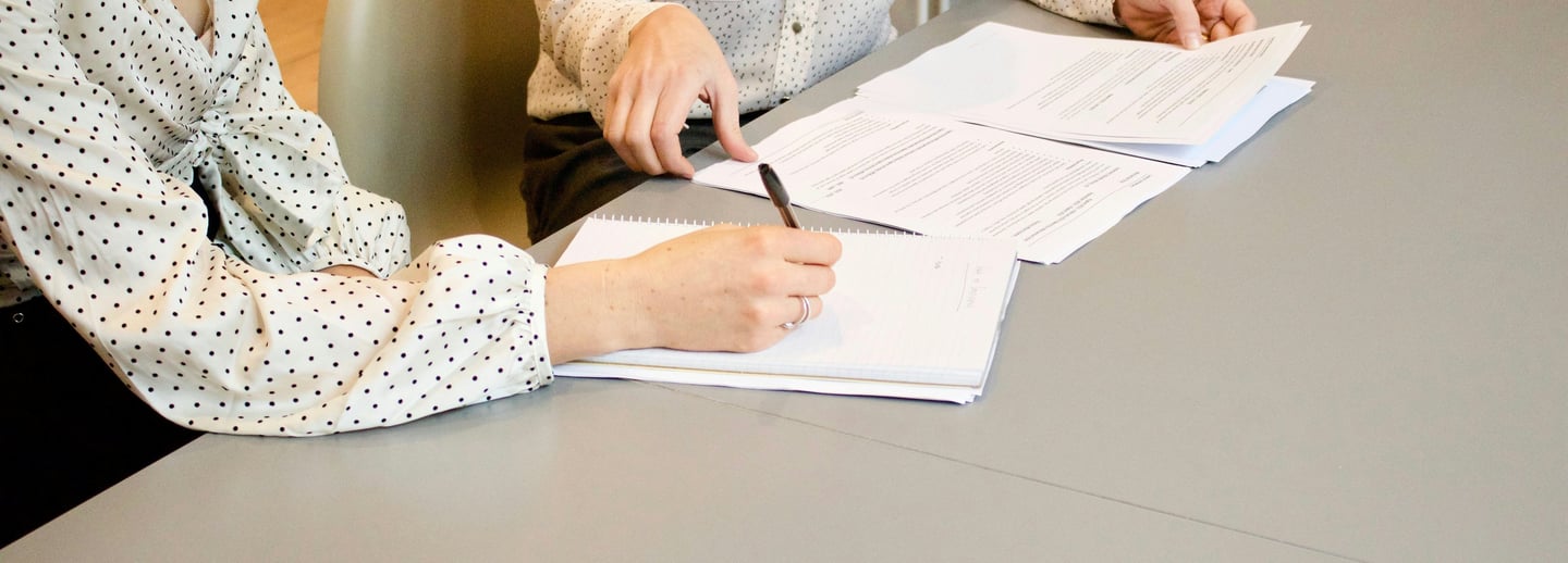 Two ladies are signing documents