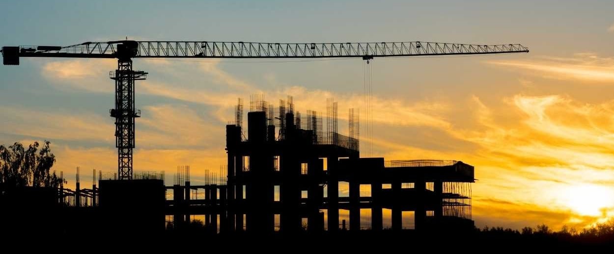 a crane is seen at sunset in this photo