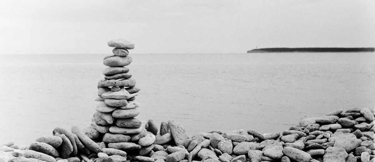 A monochrome image of a pile of stones on a stony beach
