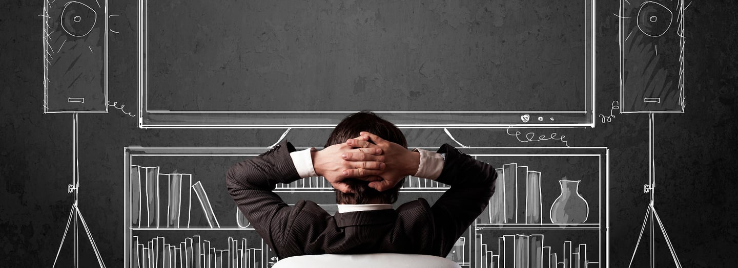 A manl sits back, visualising a large screen system, with a chalk-drawn screen