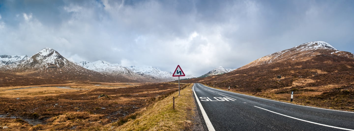 a road warning sign on road through a mountain