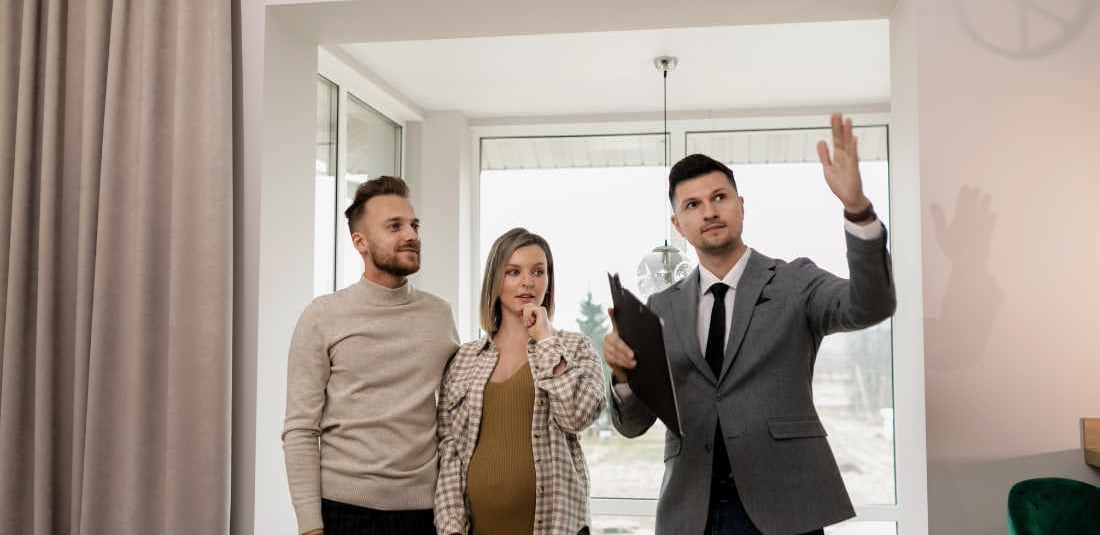 a man and woman standing in front of a window
